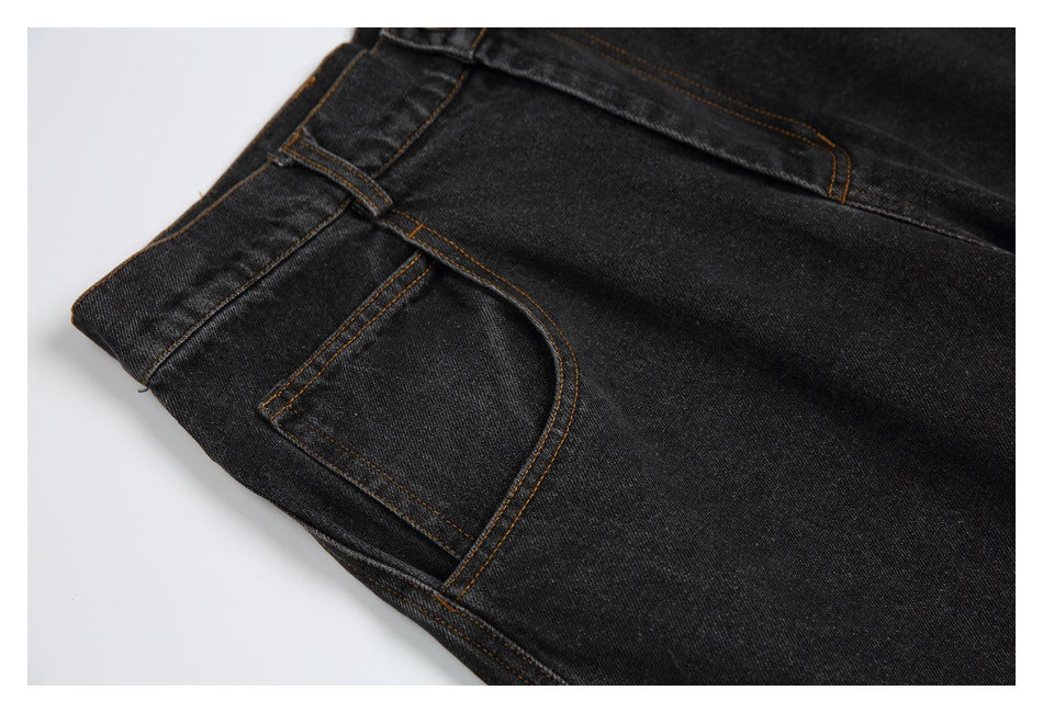 Close-up of a front pocket on black jeans, with brown contrast stitching.