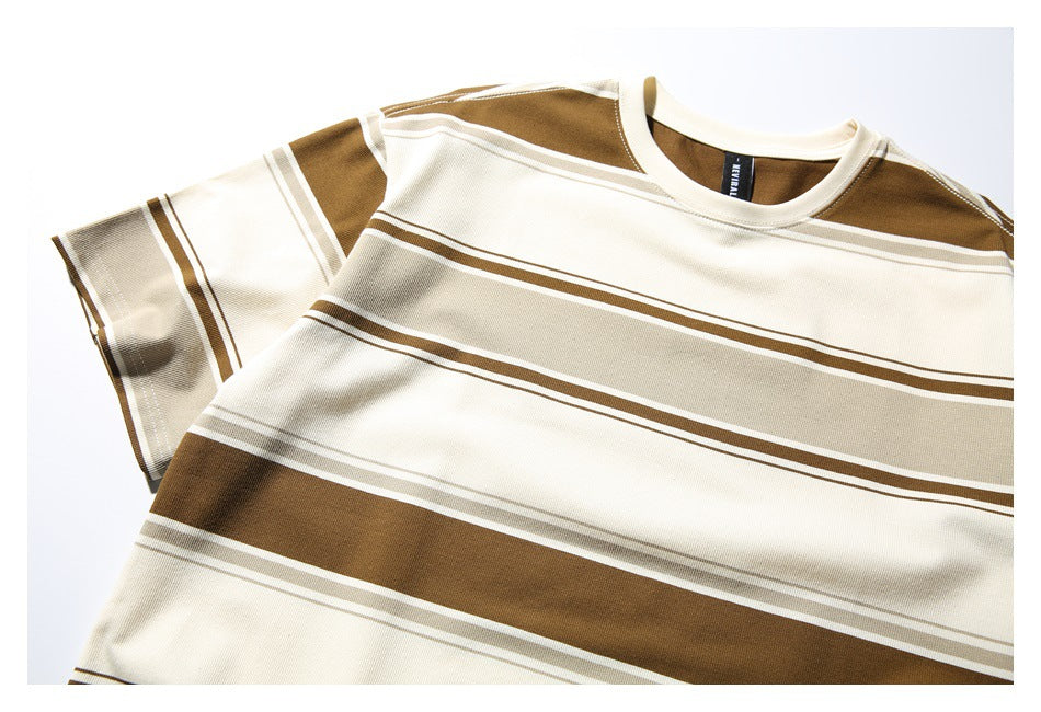 Close-up of the front of a cream crew-neck T-shirt with broad brown and taupe horizontal stripes.