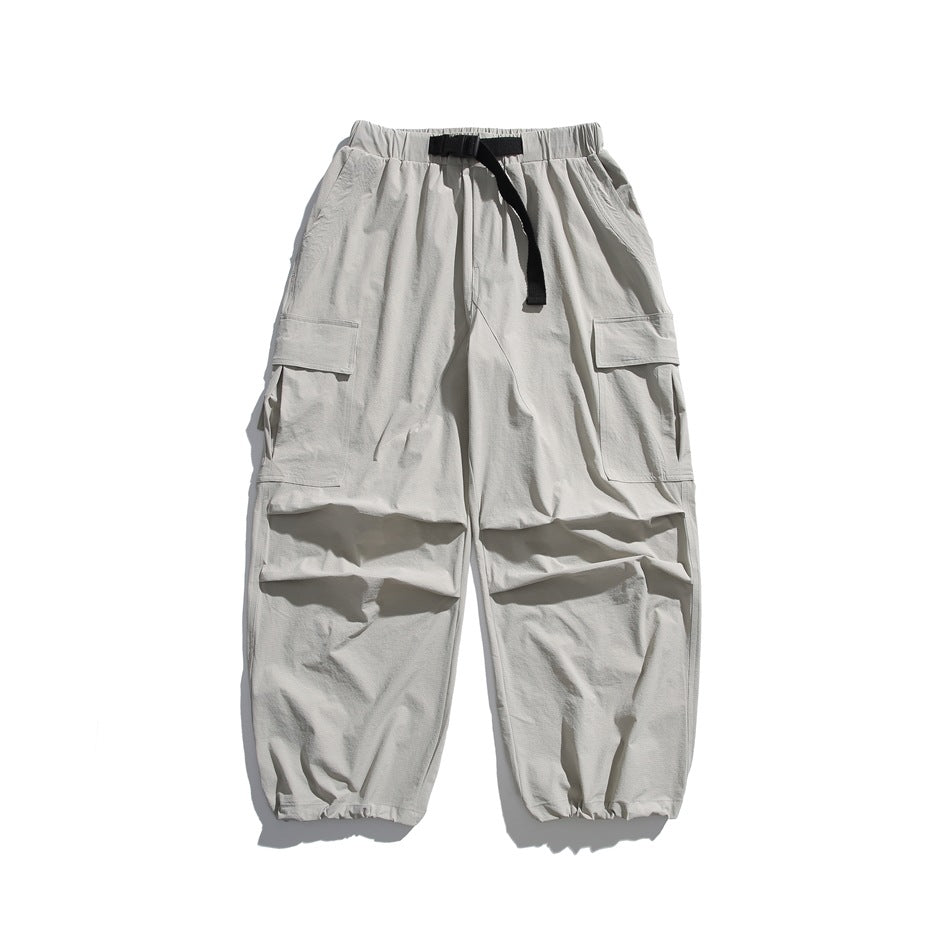 Front view of light gray cargo joggers with an elastic waist, black drawstring, large side pockets, and gathered cuffs.