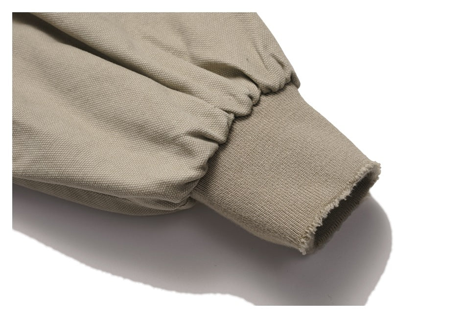 Close-up of a gathered sleeve and ribbed cuff on the light taupe jacket.