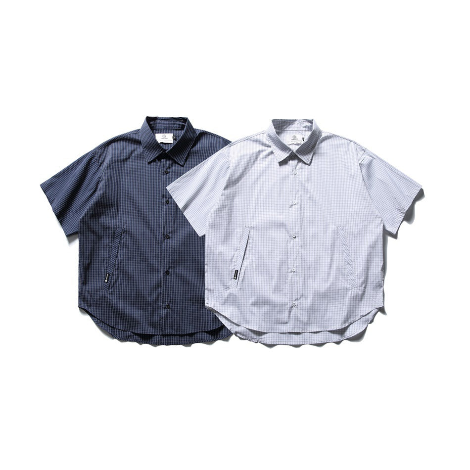 Two short-sleeve grid-check button-up shirts shown from the front in navy and light gray.
