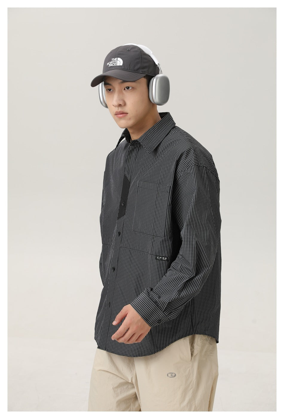 Three-quarter view of a model wearing a charcoal micro-check button-up shirt with a chest pocket.