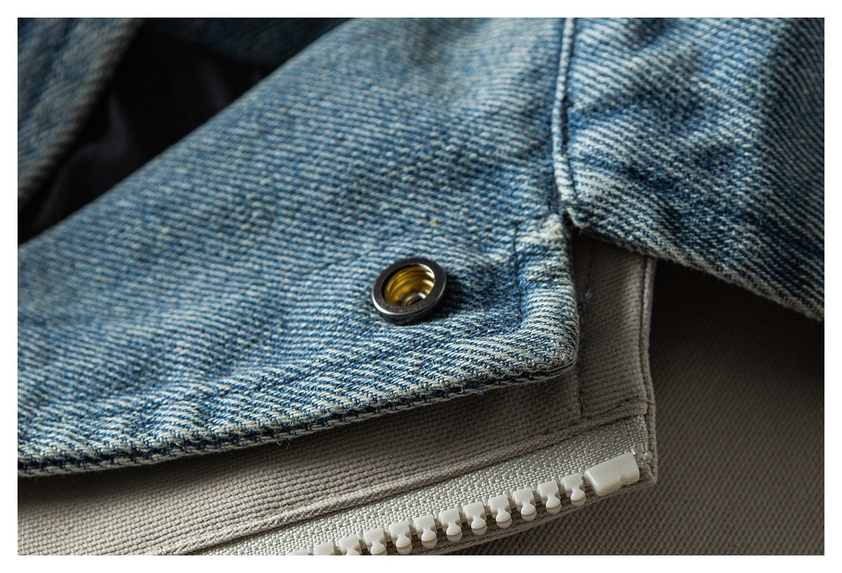 Close-up of a metal eyelet on blue denim layered over light taupe fabric and a white zipper.