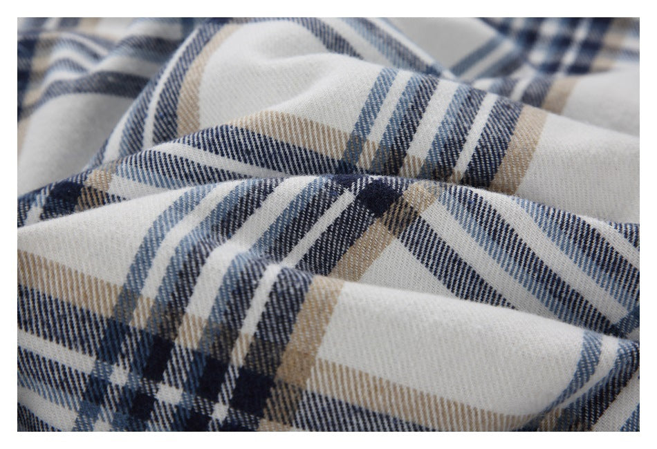 Draped close-up of white plaid fabric with navy, blue-gray, and tan lines.