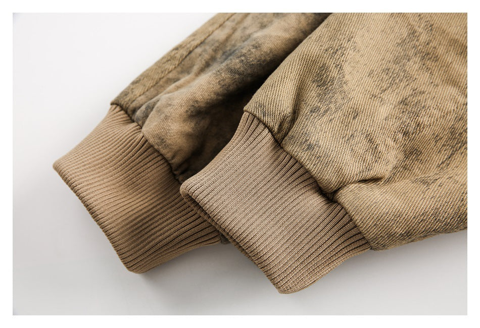 Close-up of two tan rib-knit cuffs on a mottled brown and beige garment.