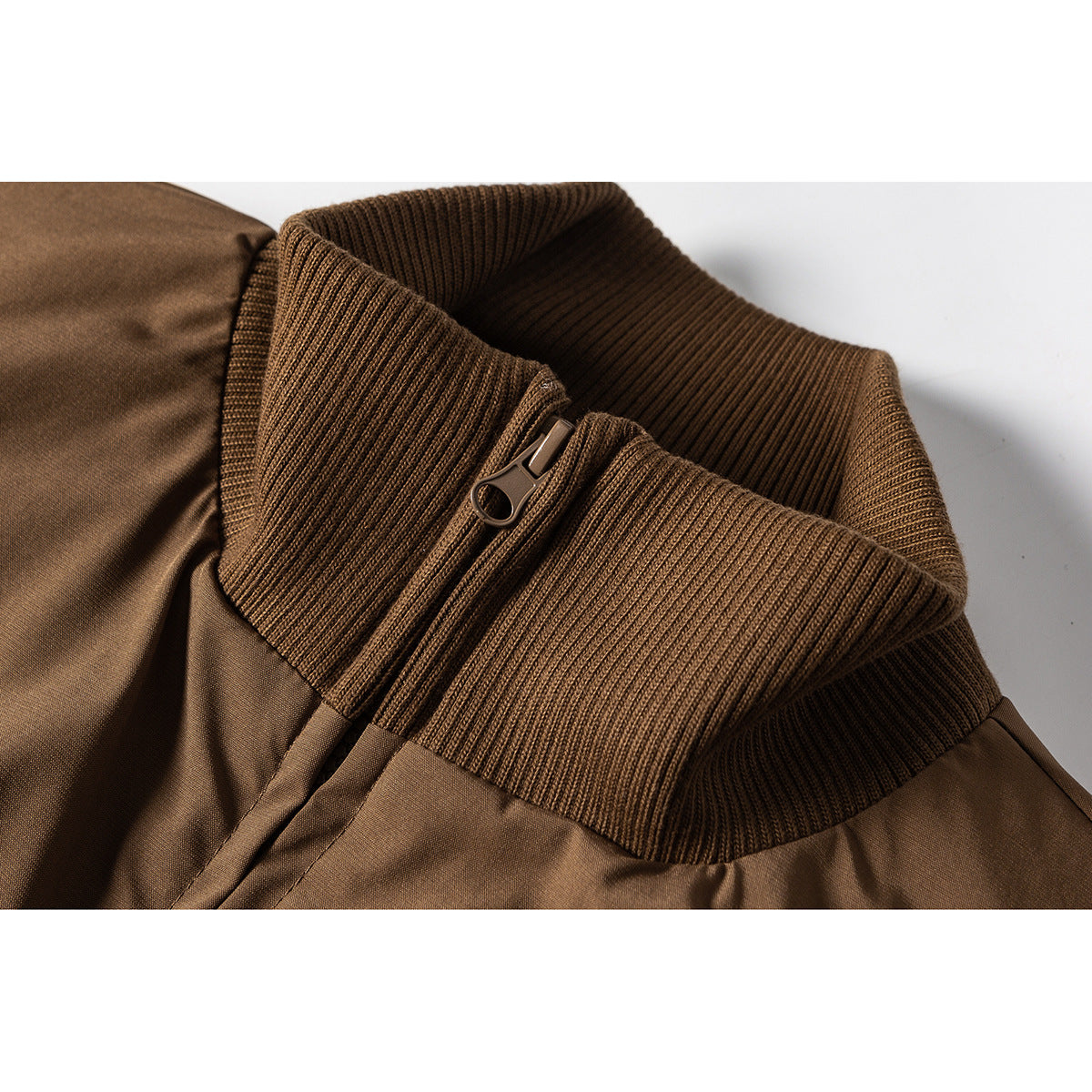 Close-up of the brown jacket's ribbed stand collar and zipper pull.