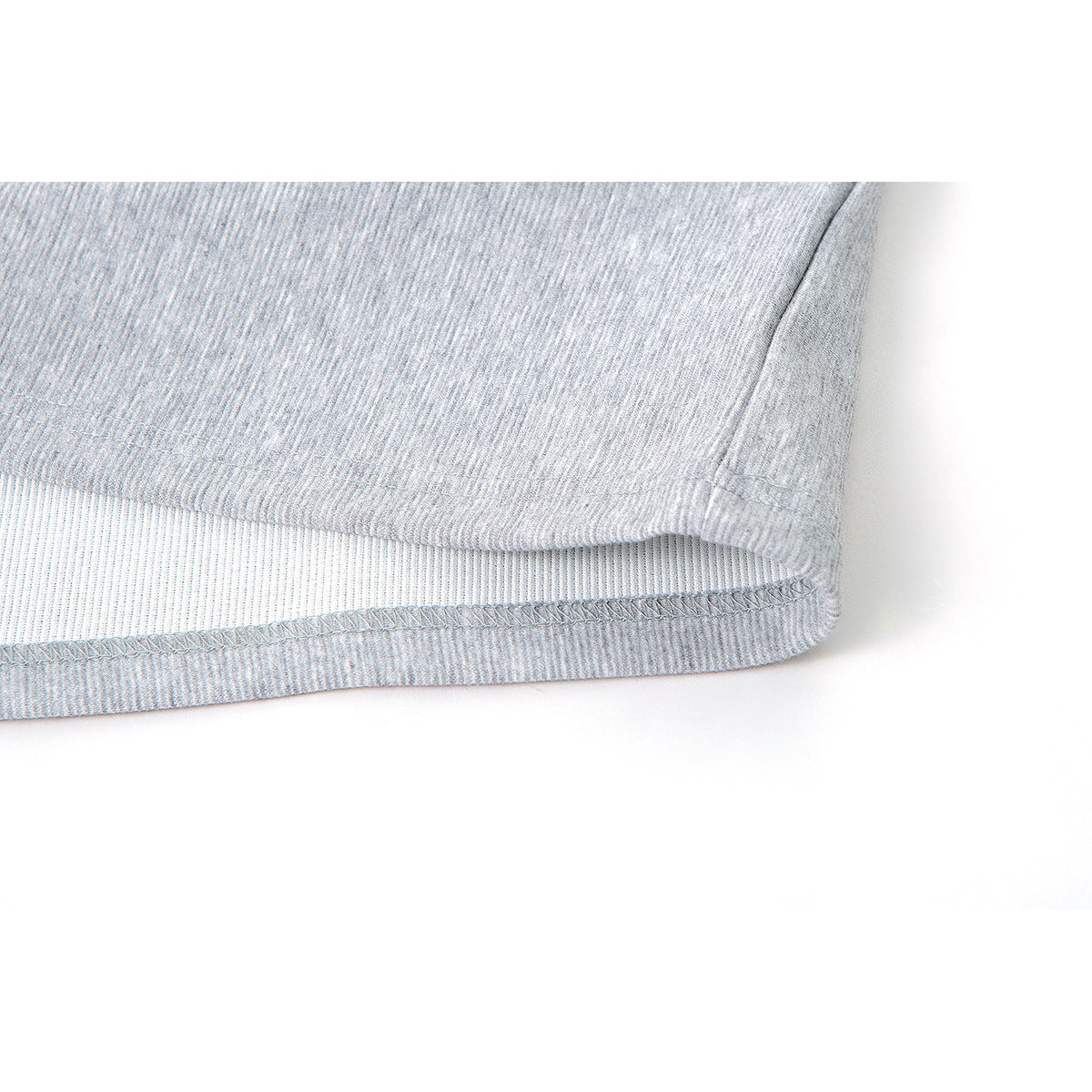 Close-up of the stitched hem and ribbed inner band of a light gray garment.