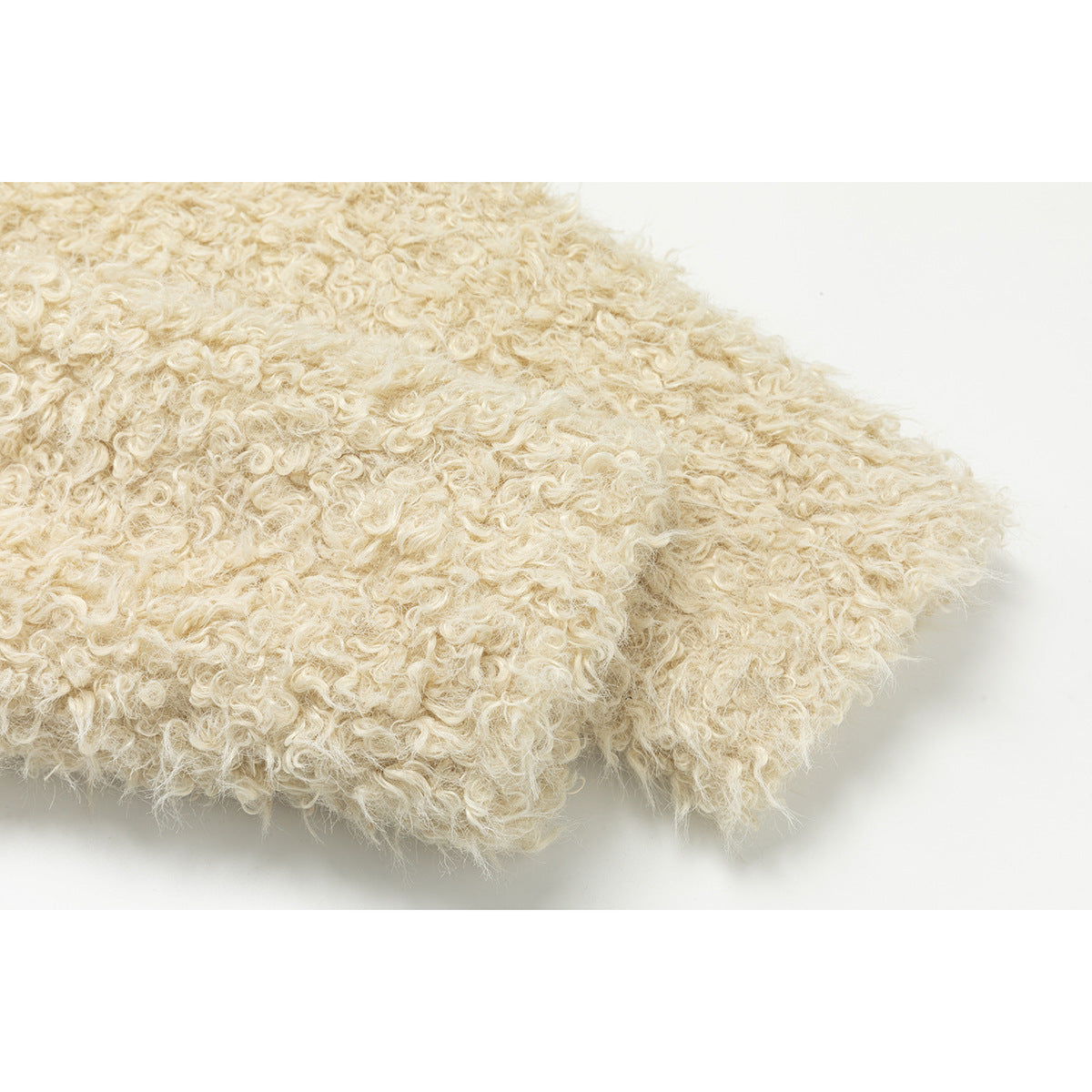 Close-up of the cream jacket’s shaggy fabric and finished edge.