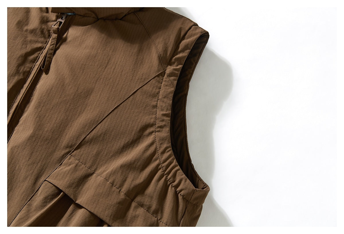 Close-up of a brown sleeveless jacket with a curved armhole, diagonal seam, and partial zipper.