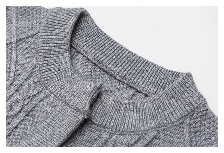 Close-up of a gray sweater's ribbed crew neckline and textured cable-knit pattern.