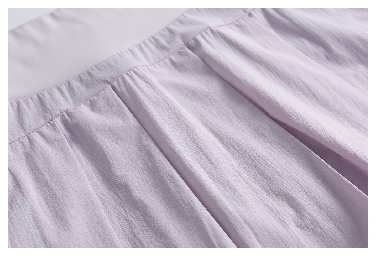 Close-up of pale lavender gathered fabric and pleats beneath a smooth upper panel.