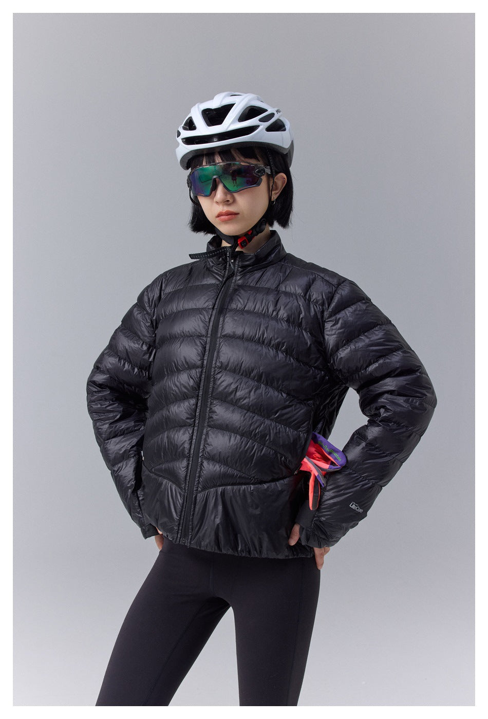 Model wearing a black quilted zip-front jacket with a stand collar and black leggings.