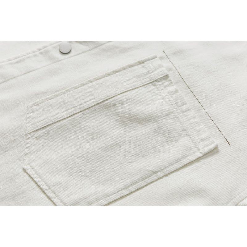 Close-up of a large stitched rectangular pocket on off-white fabric, with a snap button above it.