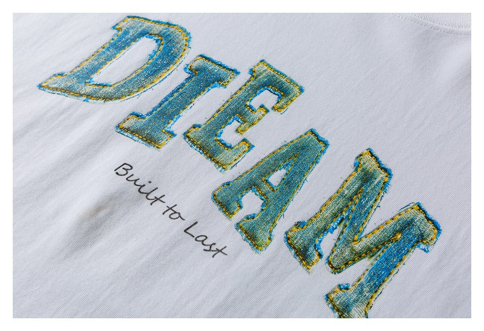 Close-up of blue-and-gold lettering and “Built to Last” print on a white T-shirt.