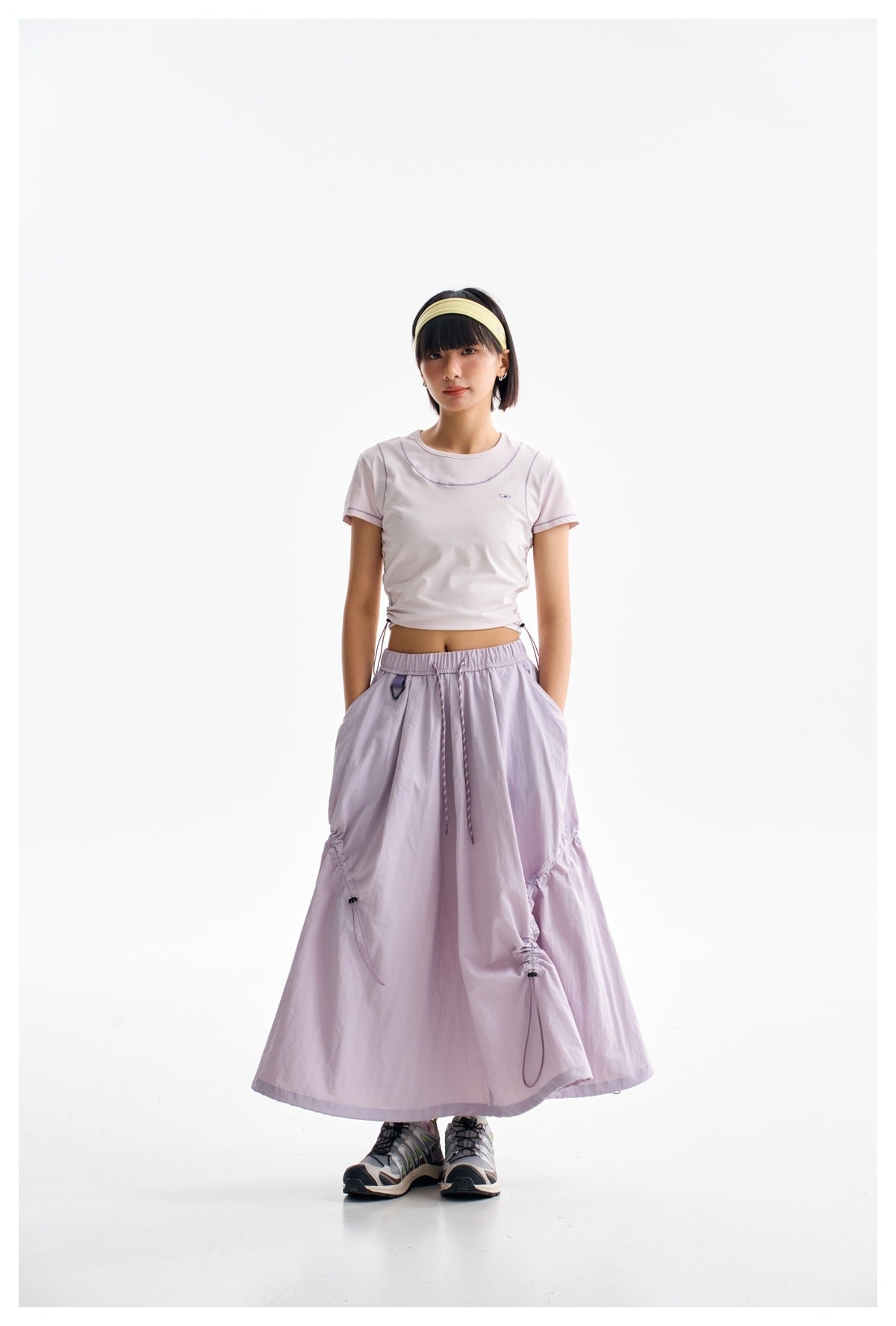 Model wearing a pale lilac cropped T-shirt and a matching long gathered skirt with drawstring details.