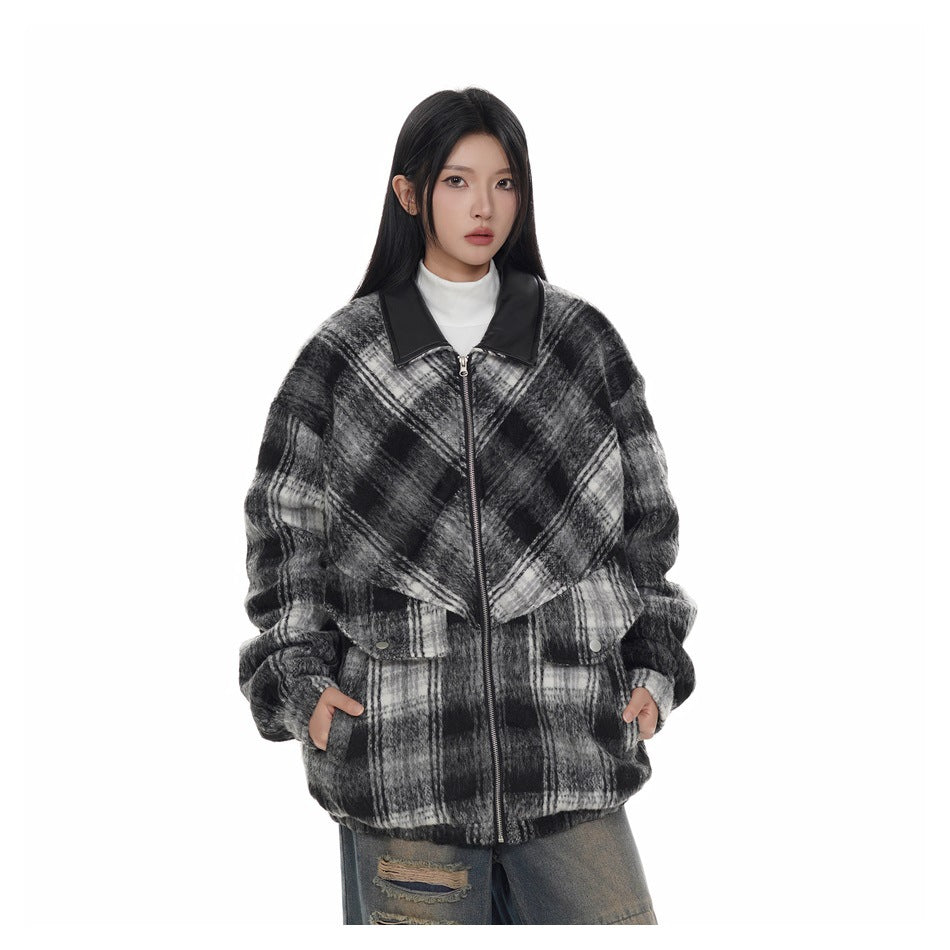 Model wearing the black and white plaid zip jacket over a white turtleneck, hands in pockets, close front view