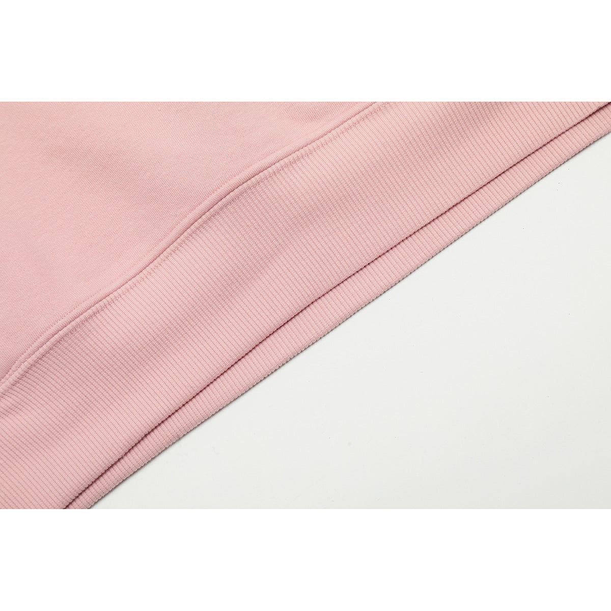 Close-up of a pink sweatshirt hem with a wide ribbed band and visible stitching.