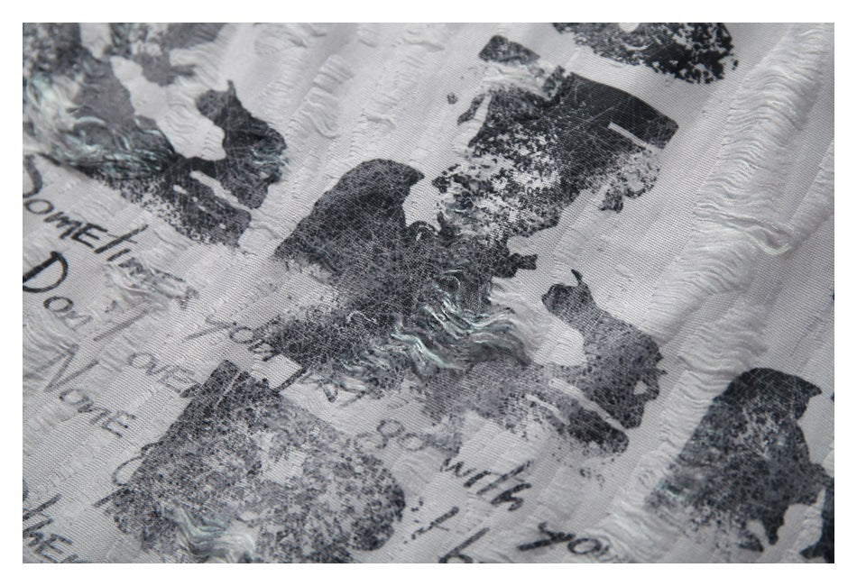 Close-up of distressed black lettering over the white garment's raised wavy stripe texture.