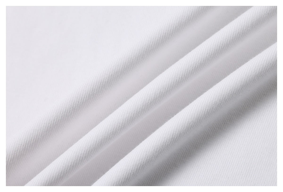 Close-up of the white T-shirt fabric draped in soft diagonal folds.