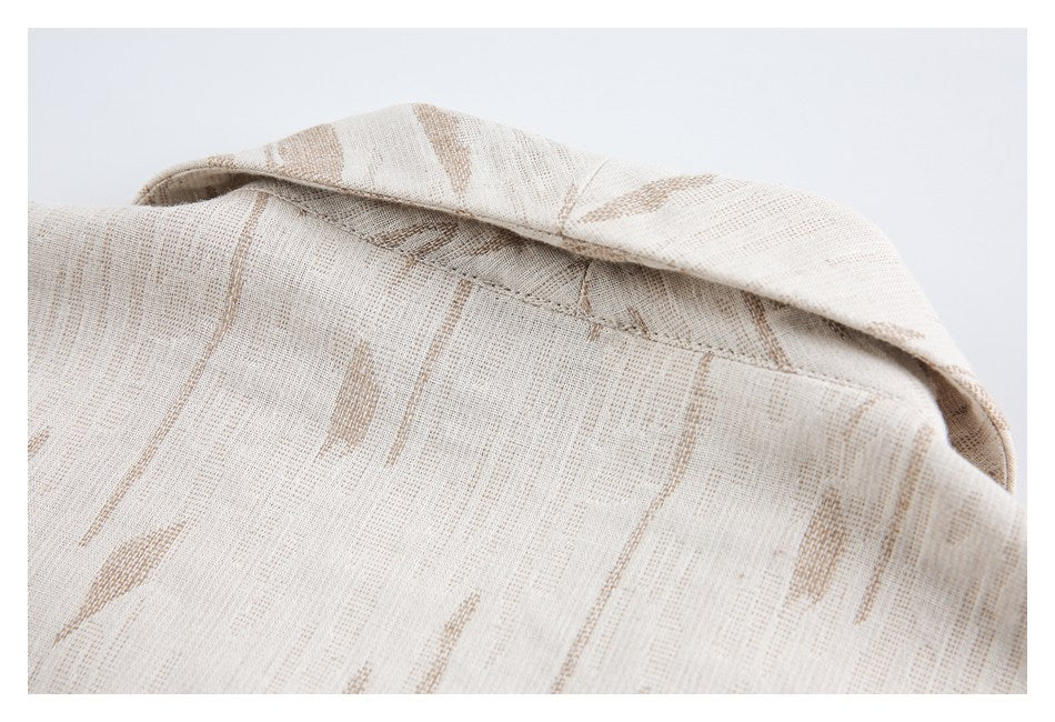 Close-up of the shirt collar and neckline in cream fabric with a tan abstract pattern.