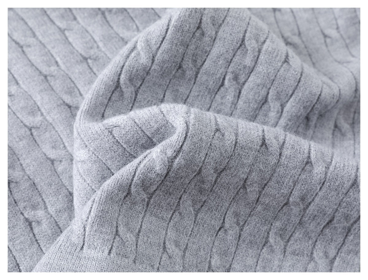 Close-up showing the raised cable-knit pattern on light gray fabric.
