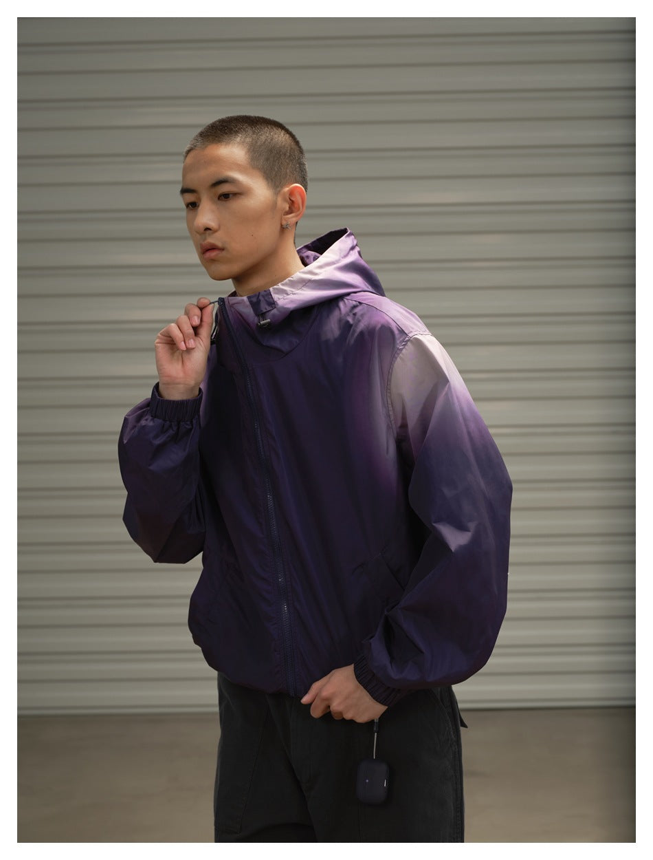 Model wearing a purple hooded zip jacket, shown from the front while adjusting the hood drawcord.