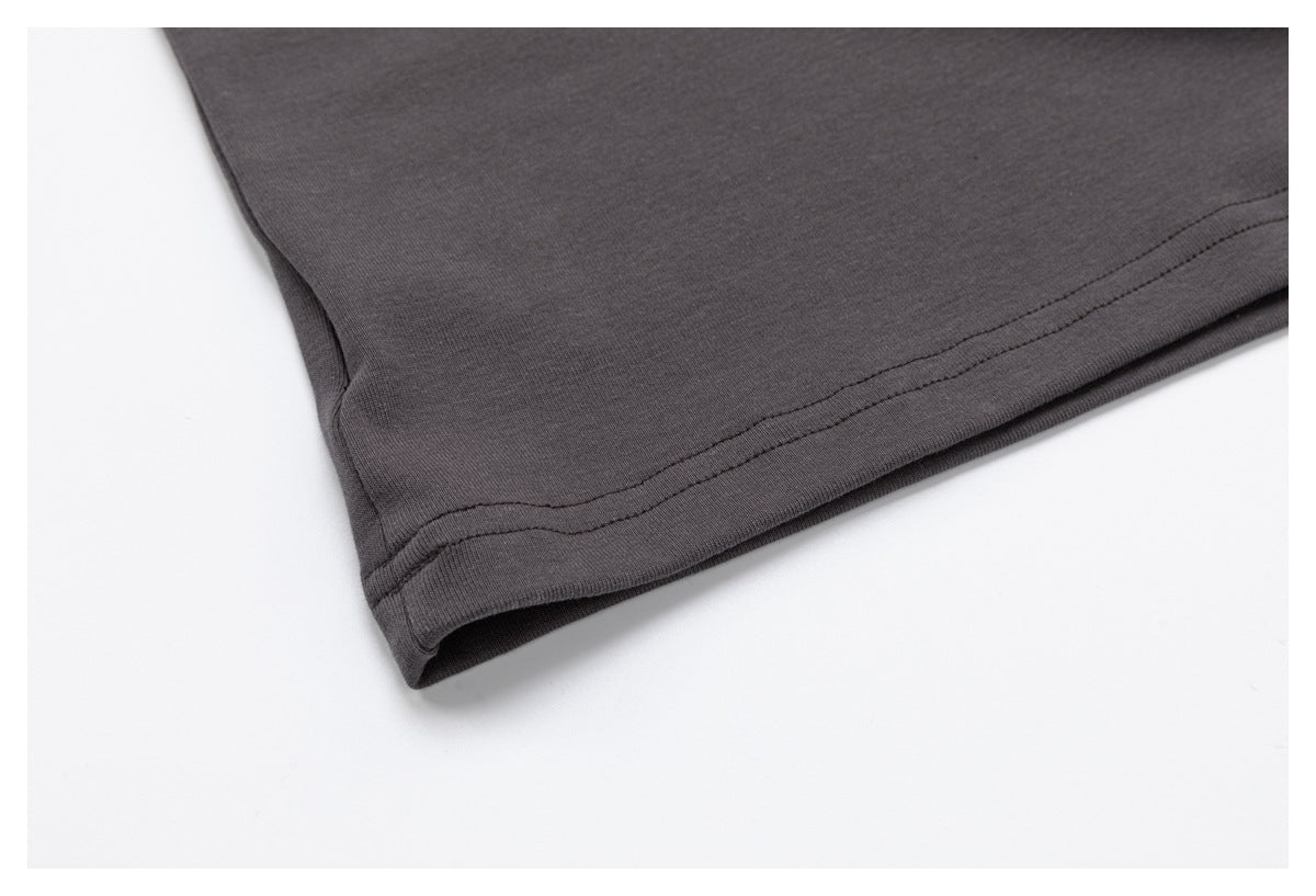 Close-up of the charcoal top's stitched bottom hem against a white background.