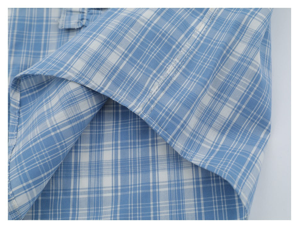 Close-up of the blue-and-white plaid shirt fabric and stitched hem.