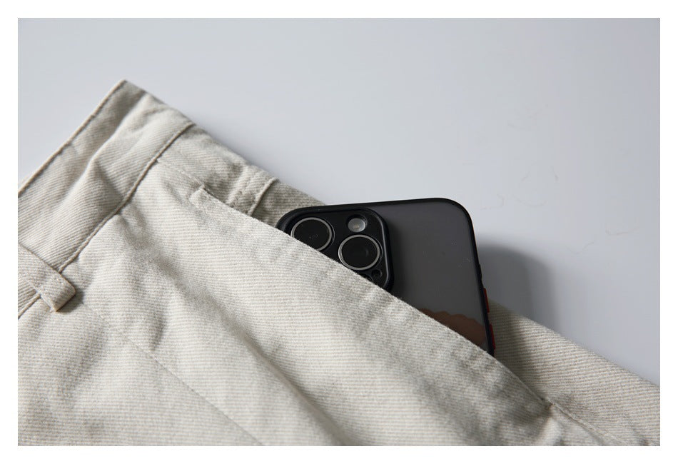 Close-up of a phone tucked into the front pocket of light beige trousers.