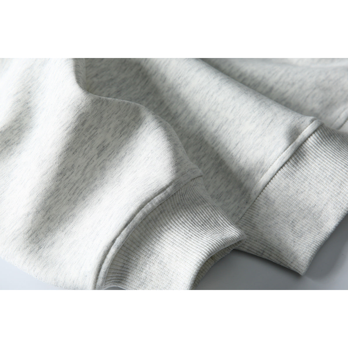Close-up of the light gray heather sweatshirt sleeve and ribbed cuff.