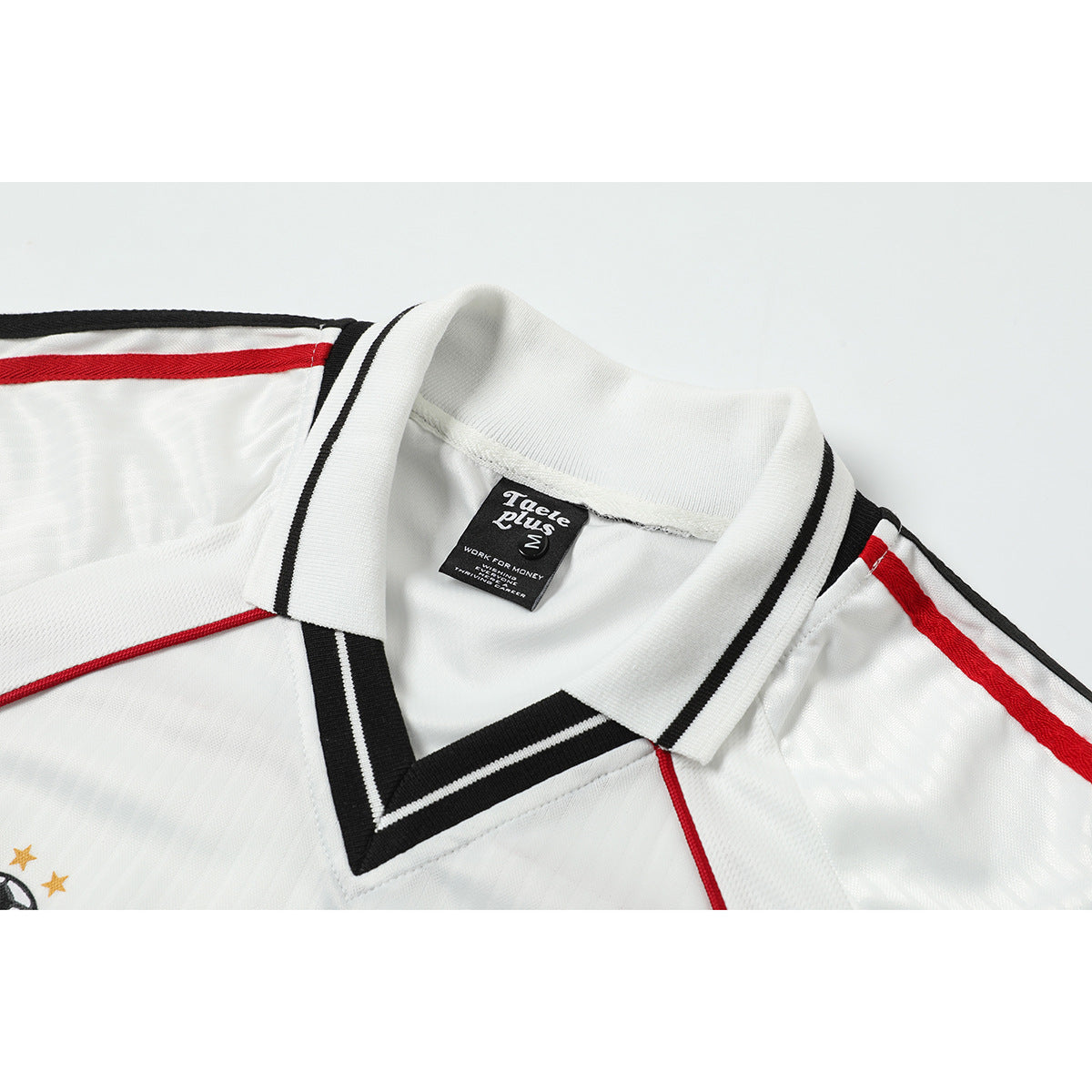 Close-up of a white jersey collar with black trim, red piping, and a visible neck label.
