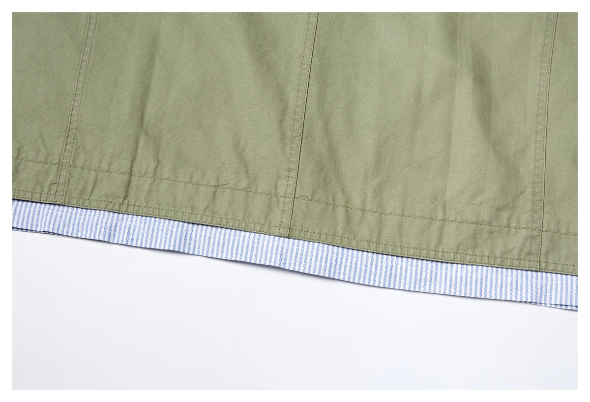Close-up of an olive garment hem finished with blue-and-white striped contrast fabric.