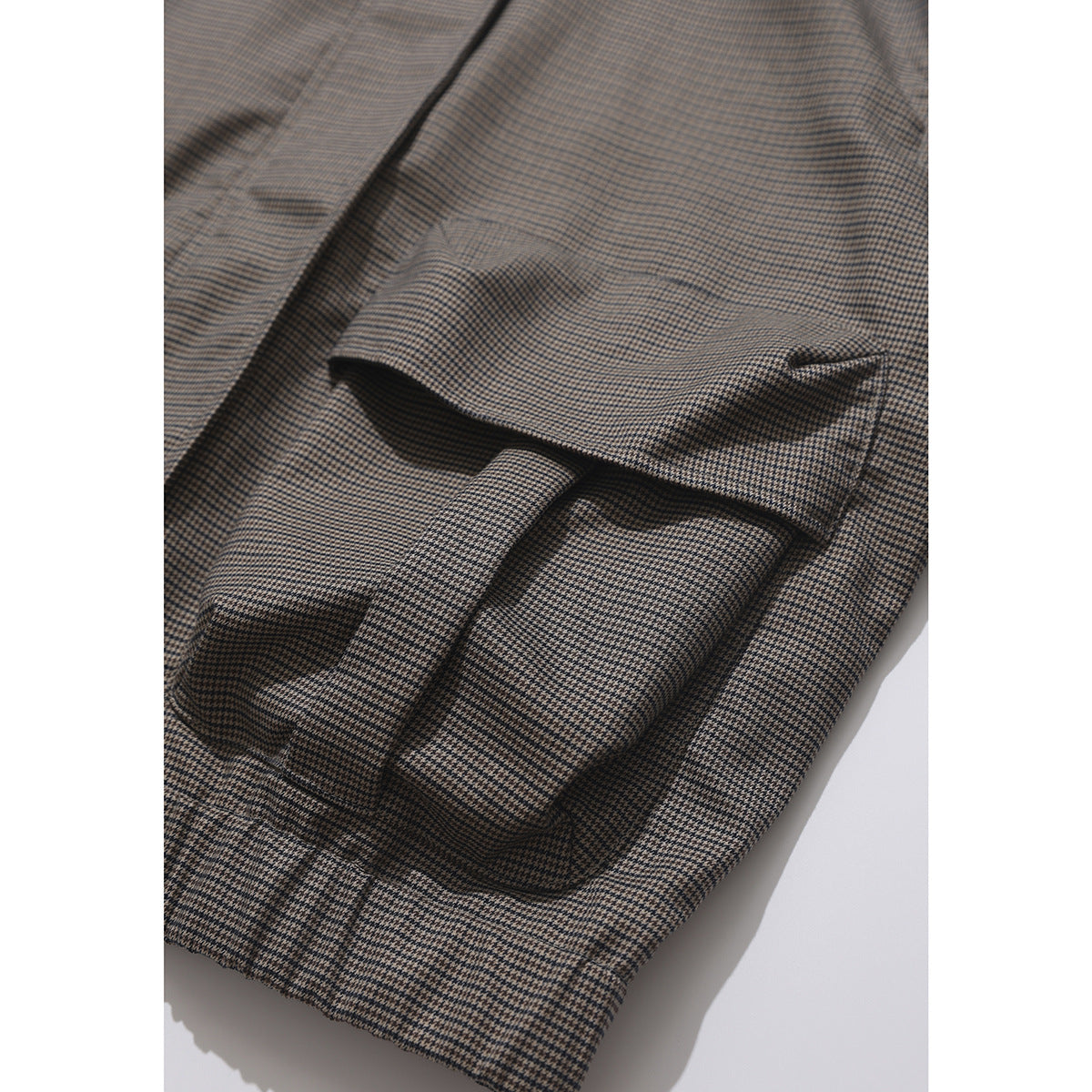 Close-up of a houndstooth jacket's flap pocket and matching cuff.