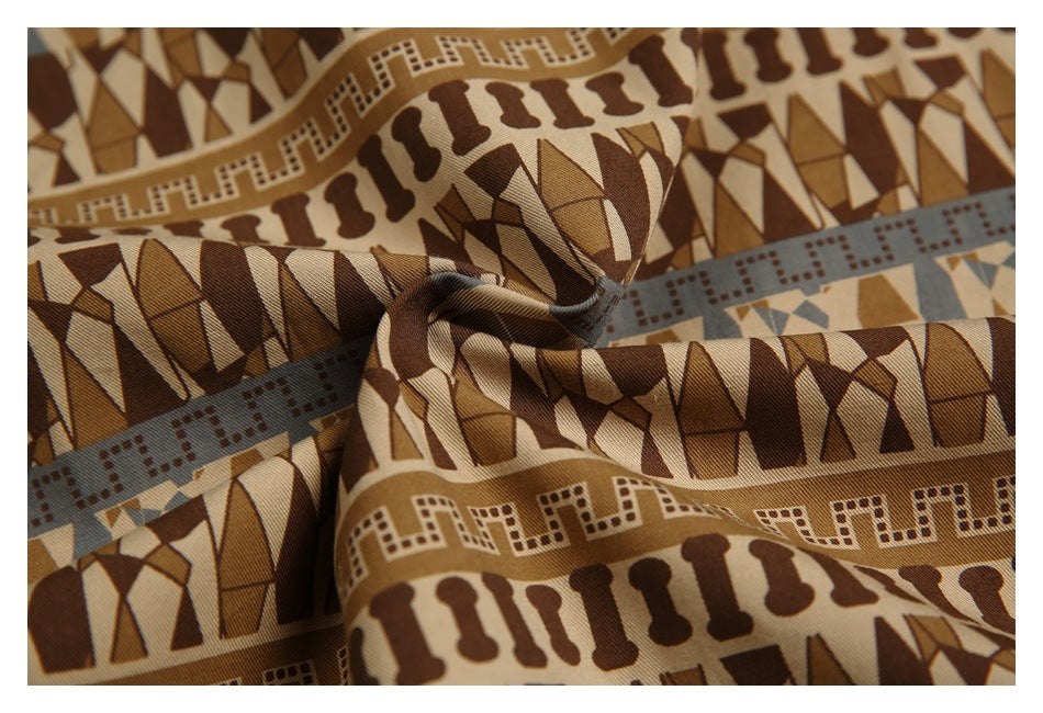 Close-up of the shirt fabric's brown, tan, and muted blue geometric pattern and drape.