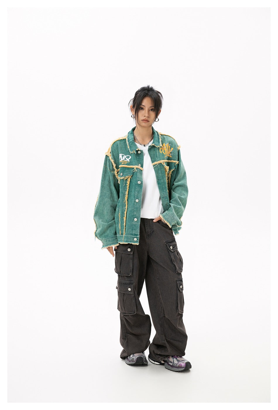 Model wearing the green frayed-edge jacket open over a white tee with dark cargo pants, front view