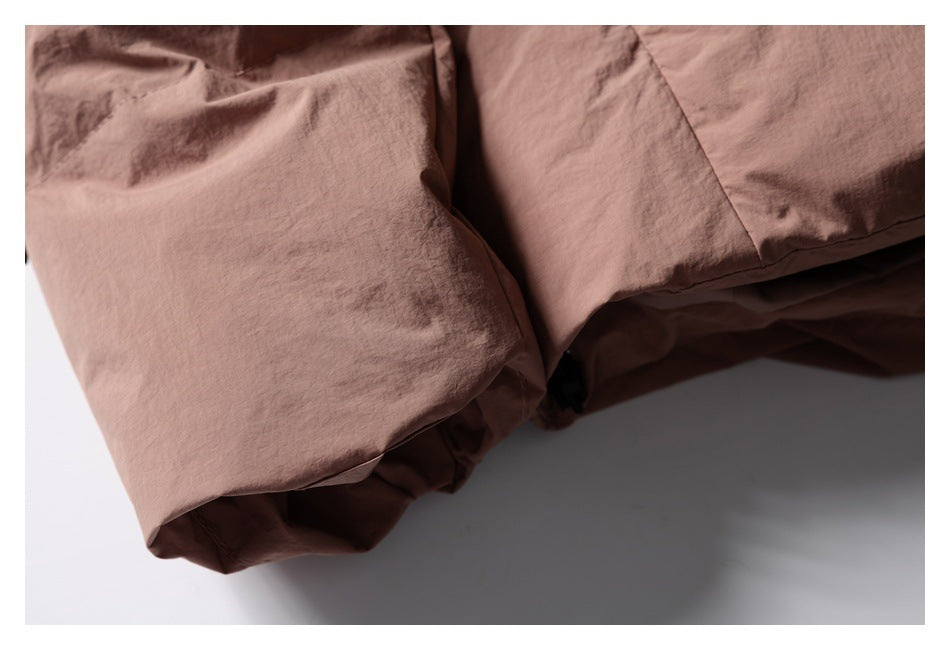 Close-up of a dusty rose jacket's folded hem and wrinkled fabric.