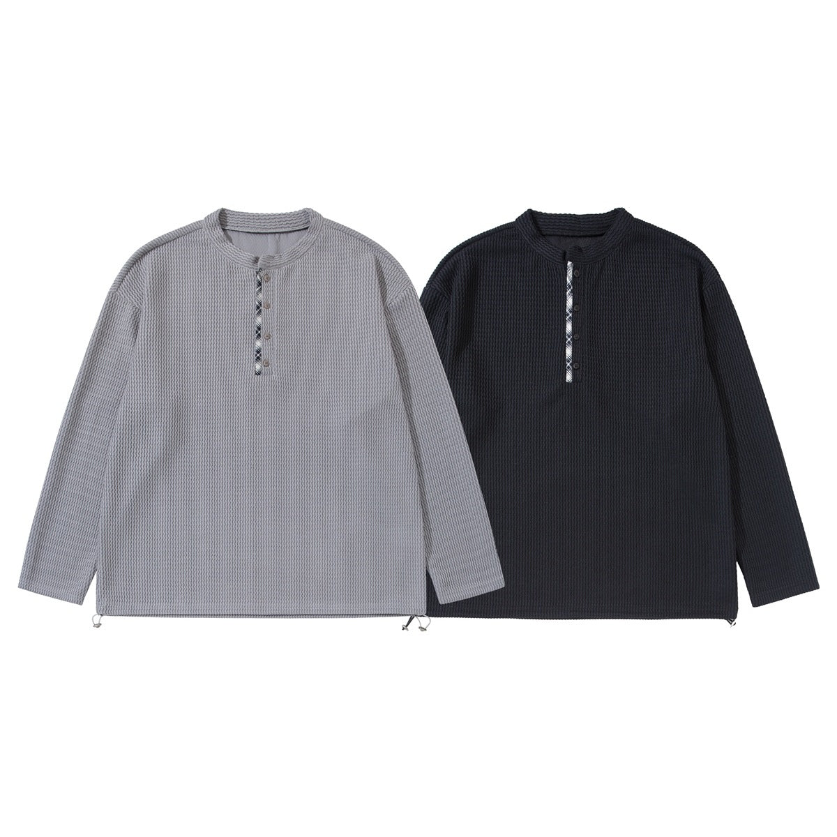 Front views of two long-sleeve textured pullover tops, one light gray and one dark charcoal, with button plackets.