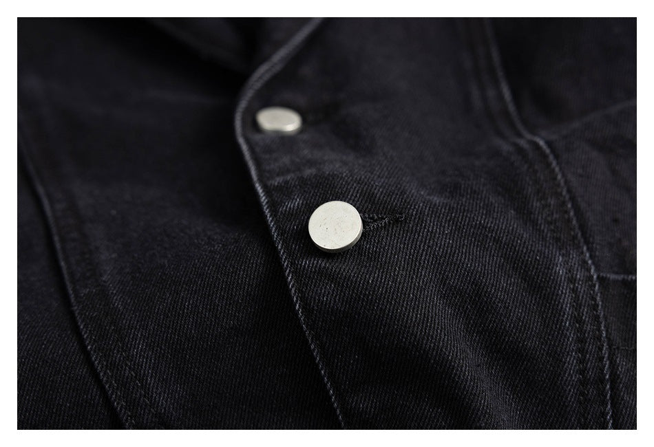 Close-up of silver snap buttons and stitching on the black jacket front.