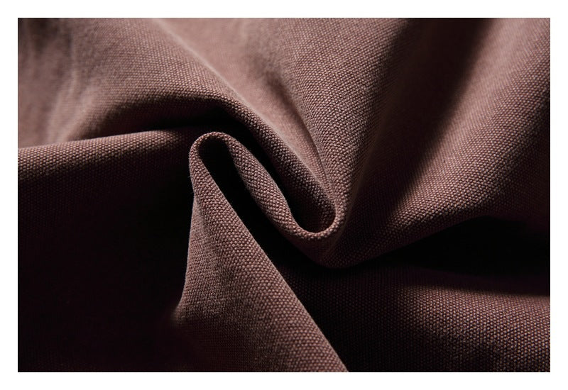 Close-up of brown woven jacket fabric folded to show its texture.