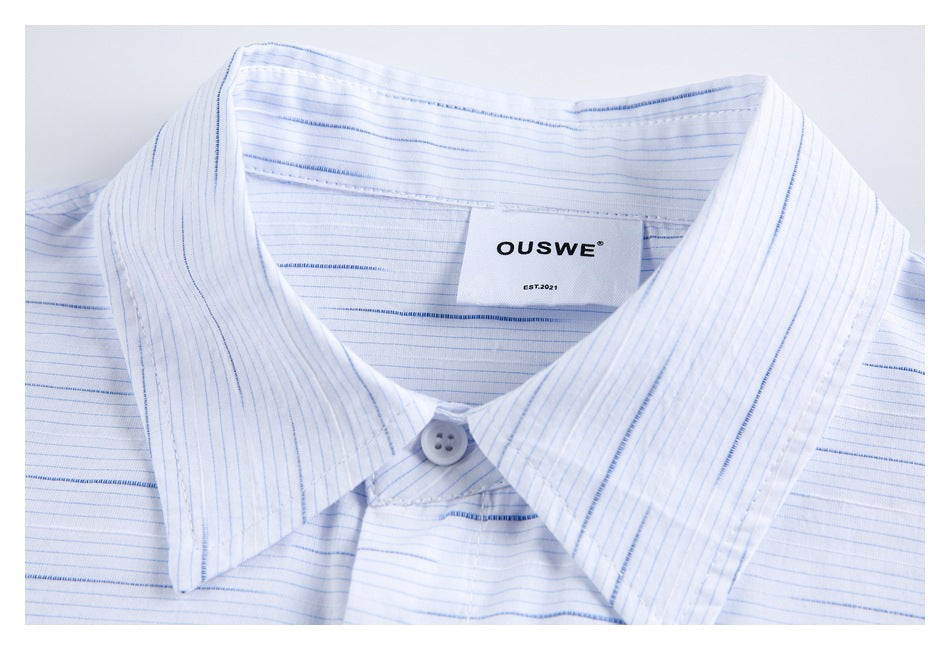 Close-up of the pointed collar and sewn-in OUSWE neck label on the striped shirt.