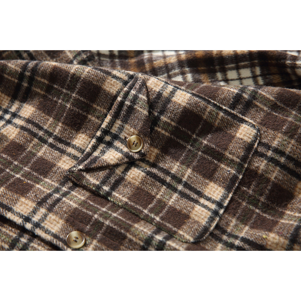 Close-up of the brown and cream plaid shirt's buttoned chest pocket and fabric pattern.