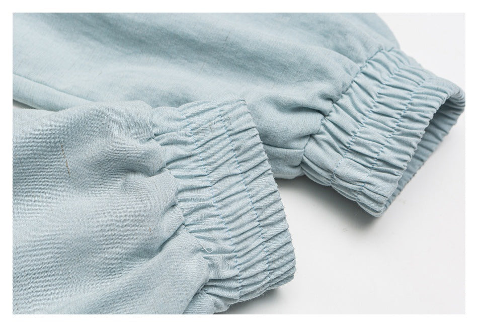Close-up of gathered elastic cuffs on pale blue garment fabric.