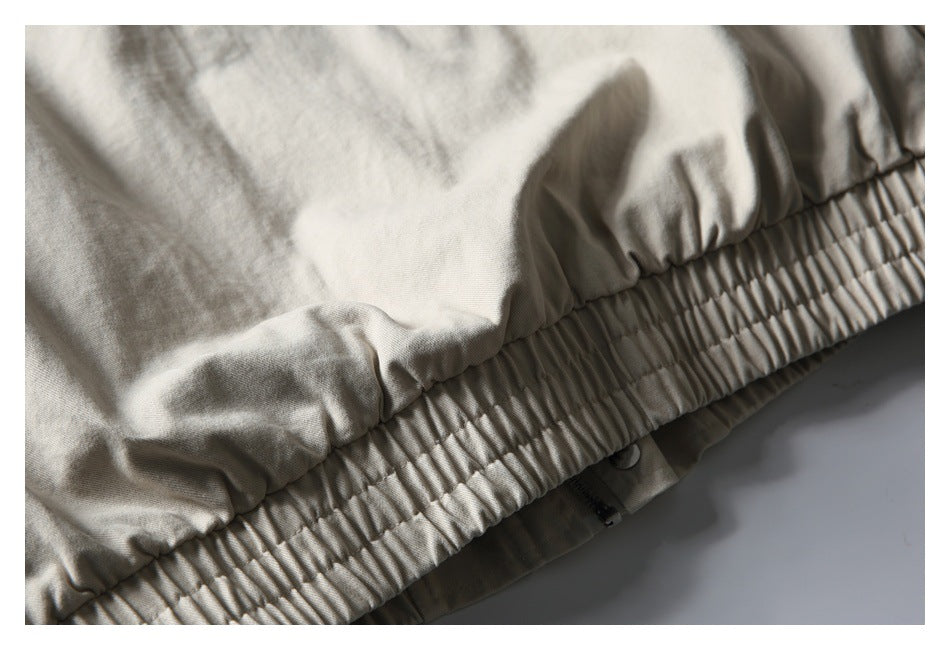 Close-up of a beige garment with a wide gathered elastic waistband and stitched seams.