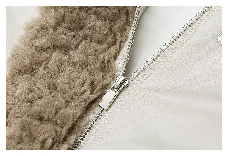 Close-up of a silver zipper beside the taupe faux-fur trim on a light beige jacket.