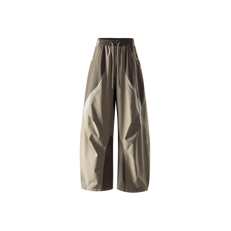 Dune khaki wide-leg drawstring pants with brown panels and cream accent seams, shown flat from the front