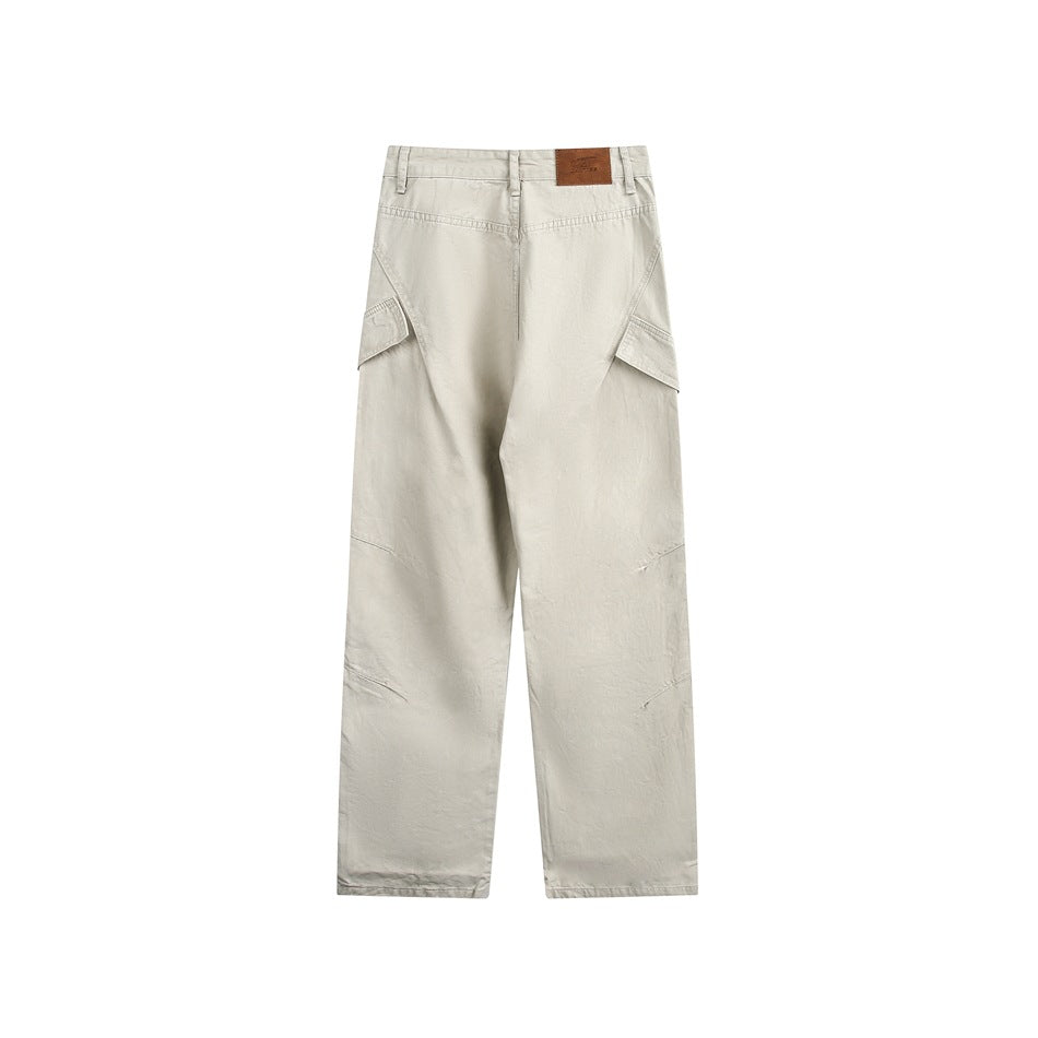Light khaki cargo pants, flat lay back view with yoke seam, side flap pockets and brown waistband patch