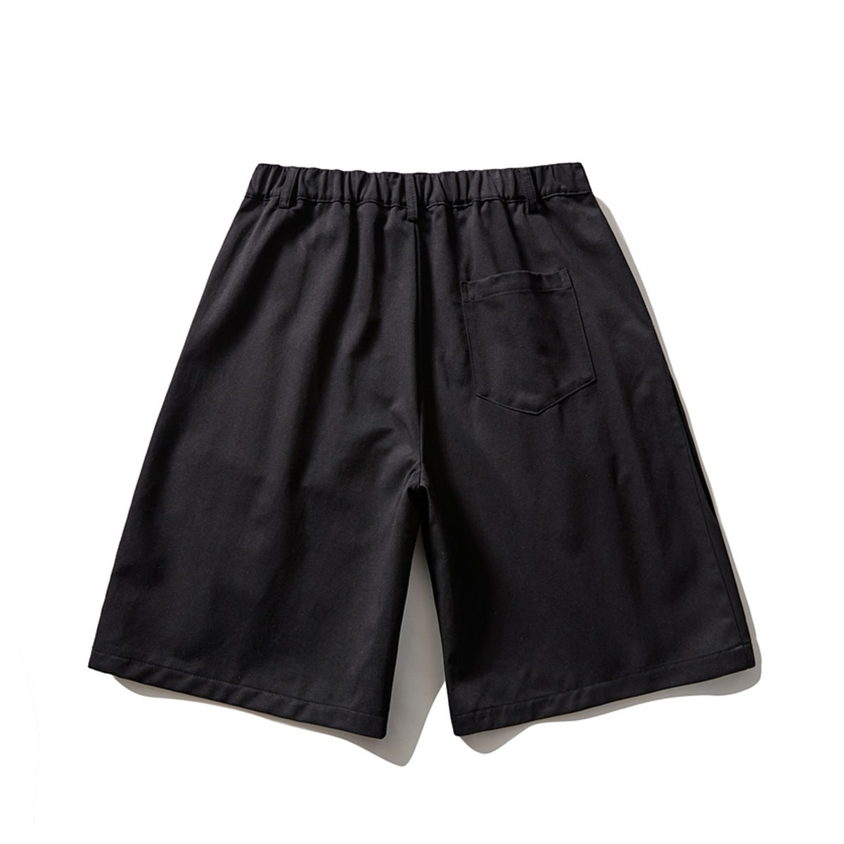 Back view of black wide-leg shorts with an elasticated waistband and a single rear patch pocket.