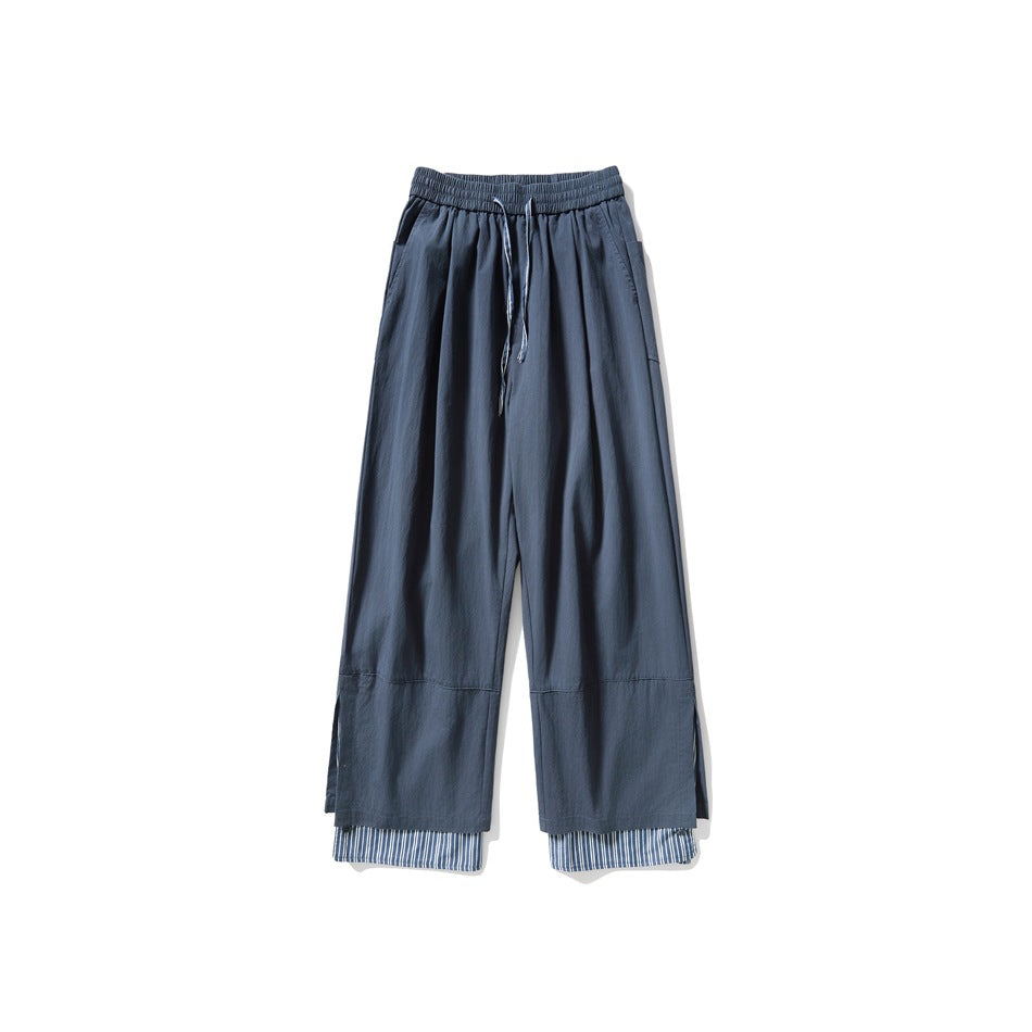 Blue wide-leg drawstring pants with a striped layered hem, flat front view