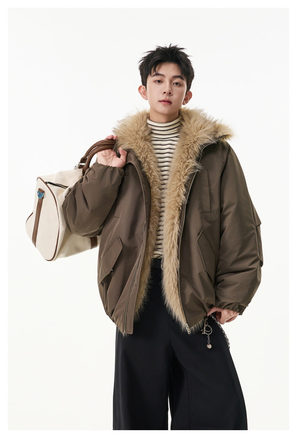A model wears a brown oversized jacket with a tan faux-fur collar, shown from the front with a shoulder bag.