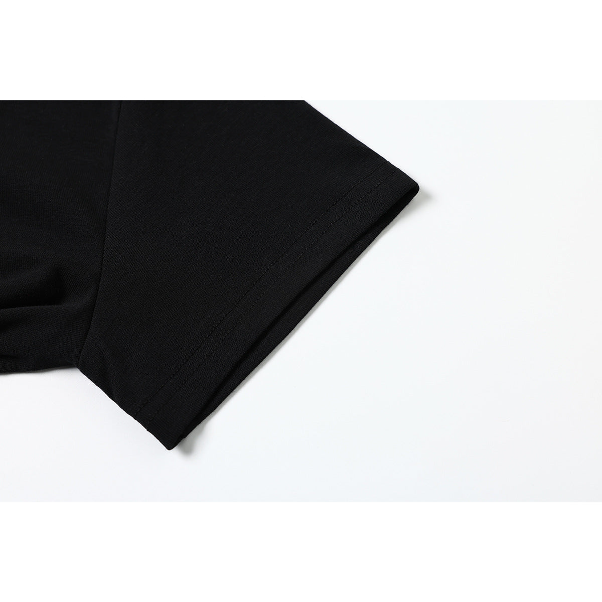 Close-up of the plain black short sleeve and stitched hem.
